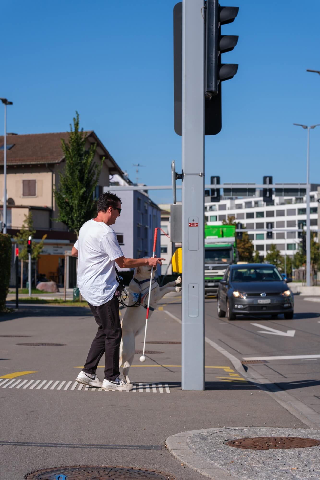 Layla weist Roger geschickt auf den Schaltknopf für die Strassenbeleuchtung hin, demonstriert ihre Assistenz bei der Umgebungsinteraktion.